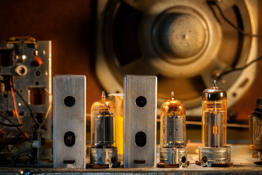 Interior of an old radio with turned on tubes and electrical components.