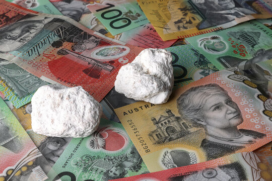 Magnesium mine, mining, production in Australia. Magnesite, magnesium carbonate, ore pieces isolated on Australian Dollar currency, money, notes. Investment, financial stock market, ASX