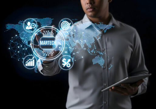 Man interacting with digital martech interface over world map holding tablet on black background