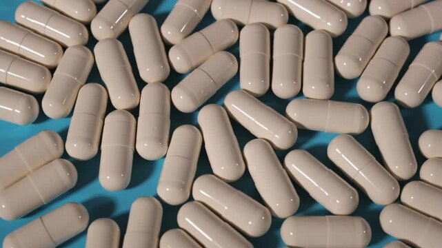Lots of pills. Blue background. Slow motion video. High quality 4k footage