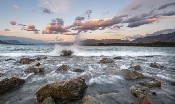 Stones on shore, lake with sunset swell, long time exposure, Lake Tekapo, Canterbury, South Island, New Zealand