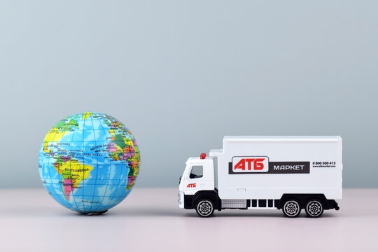 White toy truck with ATB emblem with boxes on light background, space for text.