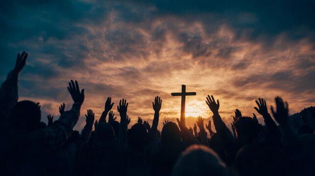 Crowd gathers outdoor for worship service with hands raised at sunset under cloudy sky