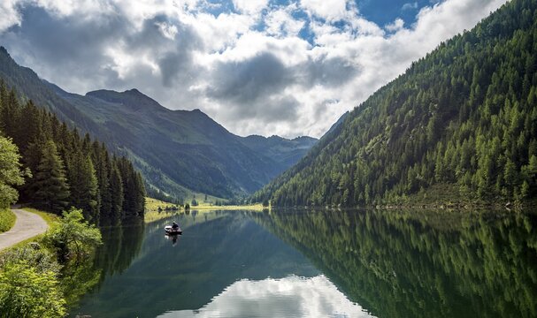 Angler in a boat, reflection in the lake, Riesachsee, Rohrmoos-Untertal, Schladminger Tauern, Schladming, Styria, Austria