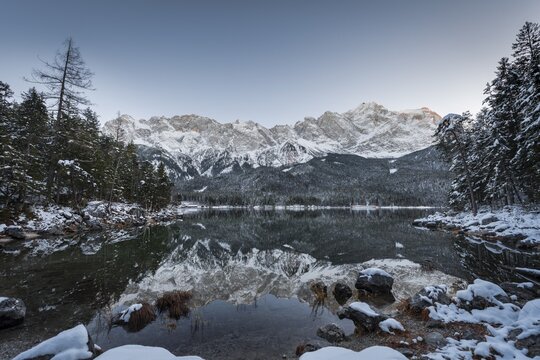 Lake Eibsee lake in winter with snow-covered Zugspitze at sunset, reflection, Wetterstein range, Upper Bavaria, Bavaria, Germany