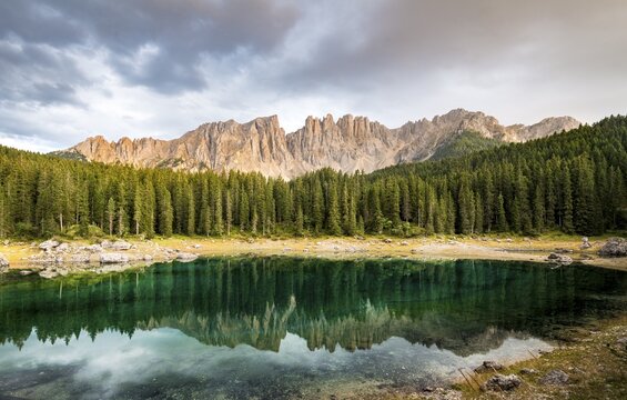 Latemar group reflected in the Karersee, Lake Carezza, cloudy skies, mountain peaks, Eastern Latemar Peak, Diamond Tower, Col Coron,  Nova Levante, Bolzano, South Tyrol, Italy