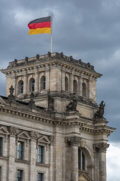 Reichstag with waving German flag at the Spree, government quarter, Berlin, Germany