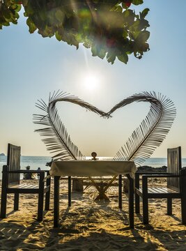 Laid table with a heart of palm fronds, sunset, Koh Samui, Gulf of Thailand, Thailand