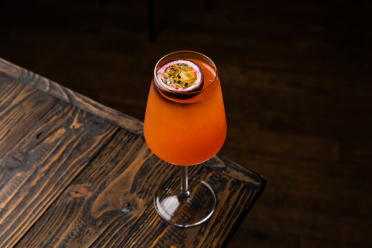 Refreshing drink with tropical flavor served on wooden table in a dimly lit bar during evening hours