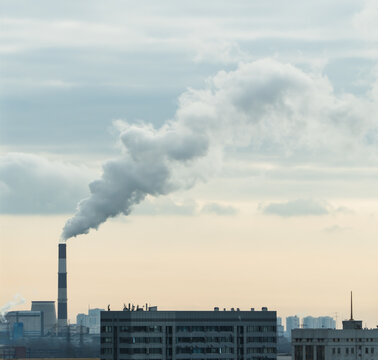Factory chimney fumes emitting pollution to the atmosphere. CO2 and greenhouse gases emissions. The chimney emits exhaust gases into the sunset sky. The concept of air pollution and the environment.	