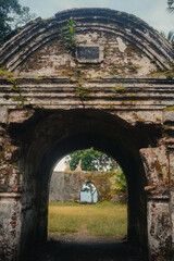 Naklejka premium Ancient stone archway leading to overgrown historical ruins