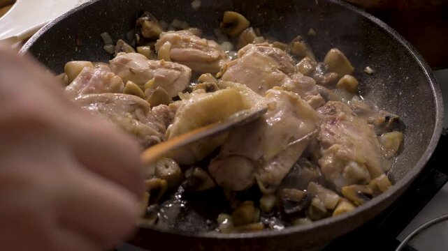 Juicy chicken with mushrooms and onions cooked in pan on stove in kitchen. Healthy and satisfying meal idea using fresh ingredients and simple techniques