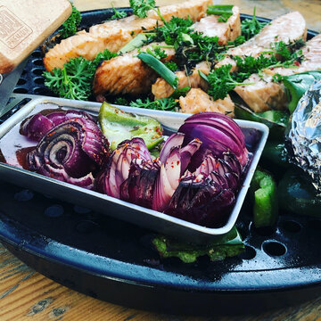 Delicious grilled salmon and red onions, fresh herbs on plate. A culinary delight for foo