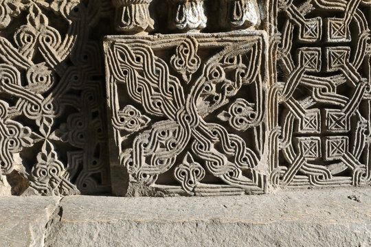 Elaborate khachkar cross stone carving featuring intricate patterns and symbolic design, showcasing ancient armenian religious artistry and heritage at a historic monastery wall