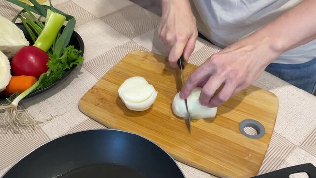 white meal prepper slices and dices onion on bamboo cutting board with sharp knife, steady fingers shaping uniform pieces, fresh produce basket nearby, bright prep surface and domestic calm