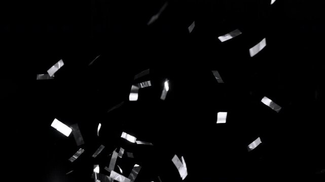 Super slow motion of flying confetti isolated on black background. Filmed on high speed cinema camera