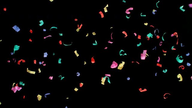 Super slow motion of flying confetti isolated on black background. Filmed on high speed cinema camera