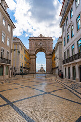 Naklejka premium Perspective view of Rua Augusta street leading to famous arch in Lisbon, elegant buildings and patterned pavement in Baixa district, iconic urban landmark and travel destination Portugal