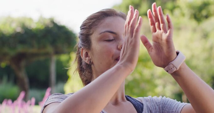 African American woman starting inhaling raising arms pressing palms calming in park in grey top