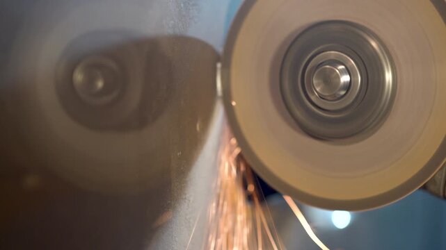 Cutting metal with a grinder in a workshop with sparks flying during the process
