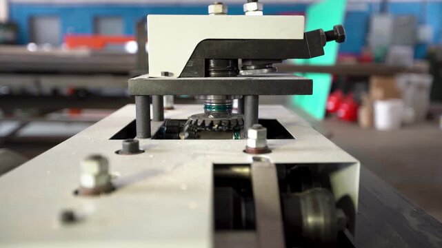 View of a machine working in a factory with parts and tools involved in metal processing.