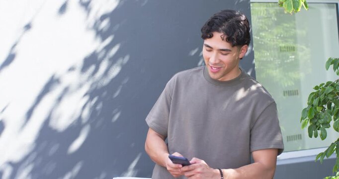 Adult man glancing at smartphone beside dark gray wall, checking messages, causing animated tech UI