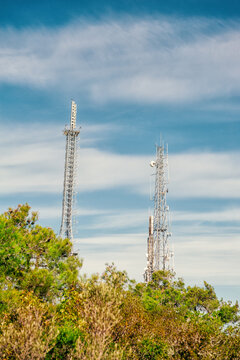 Telecom towers with antennas under blue sky