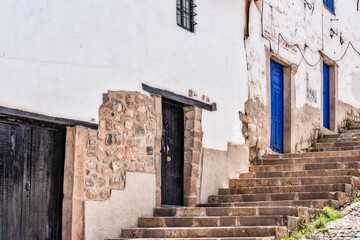 Fototapeta premium Narrow street with stone steps and traditional colonial houses in Cusco, Peru
