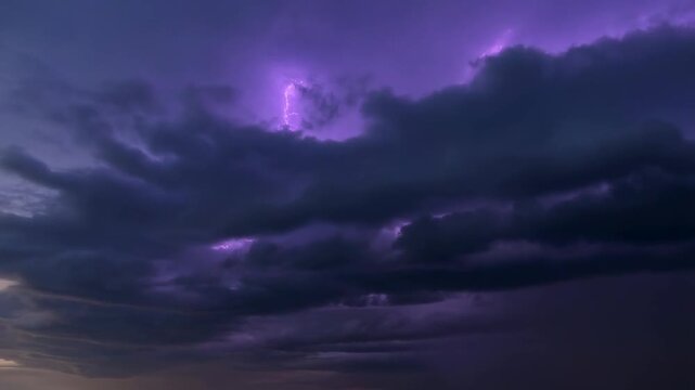 Dramatic thunderstorm clouds illuminated by lightning strikes at dusk. Captivating display of nature's power and beauty, perfect for weather-related projects