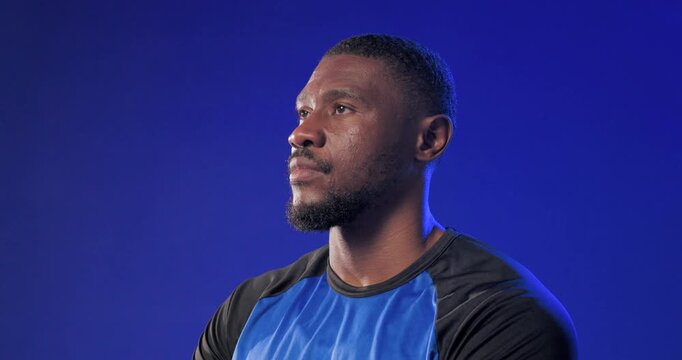 Camera tightening, mid adult man turning head for close studio portrait, wearing blue sport shirt
