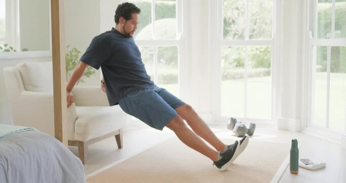 African American man starting triceps dips on chair in bedroom corner, drinking from green bottle