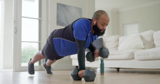 African American man starting plank on hex dumbbells at home, alternating rows and pushups for core