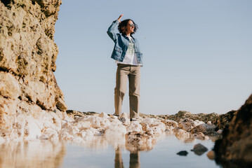 Woman stands barefoot on salt-encrusted rocks © Reuben