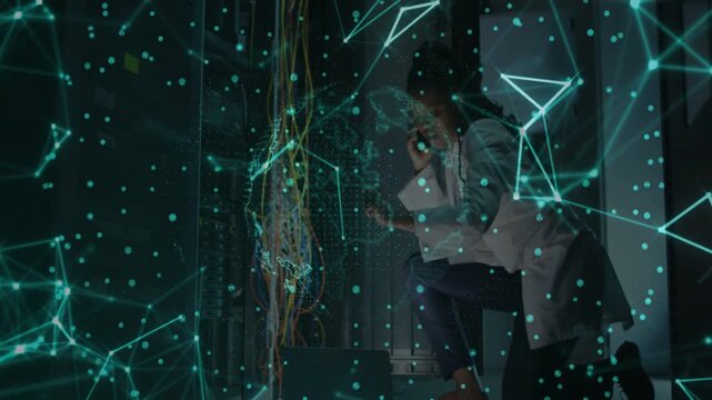 Female tech taking call and fixing network, kneeling at rack and moving patch cables with hologram