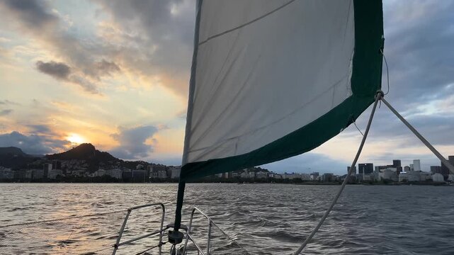 Coastal city skyline seen from sailboat at sunset in Rio de Janeiro Brazil