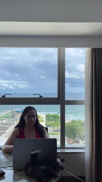 Digital nomad woman working on computer with beautiful sea view in Brazil in Brazil Rio de Janeiro look down camera medium shot