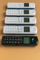 Obraz premium Collection of Cordless Landline Handsets on Brown Surface