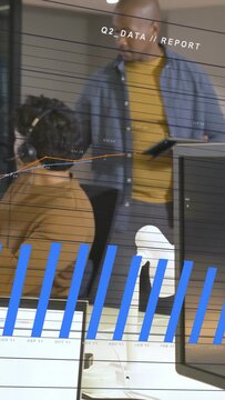 Vertical video: Headset rep typing while lead checking tablet causing Q2 charts rising for report