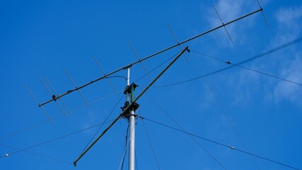 Fototapeta premium Tall VHF radio antenna with a stay ropes against a blue sky