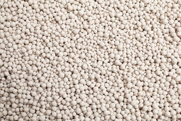 Fototapeta premium Foam glass granules in various sizes scattered on a flat surface, showcasing a light-colored substrate ideal for soil enhancement and horticultural applications