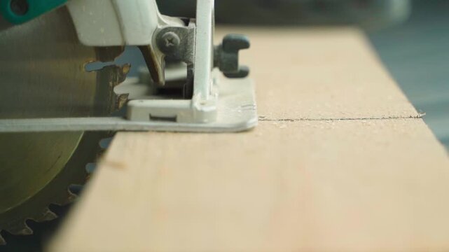 Circular saw being positioned on wooden board close-up. Black marker line marks cutting point