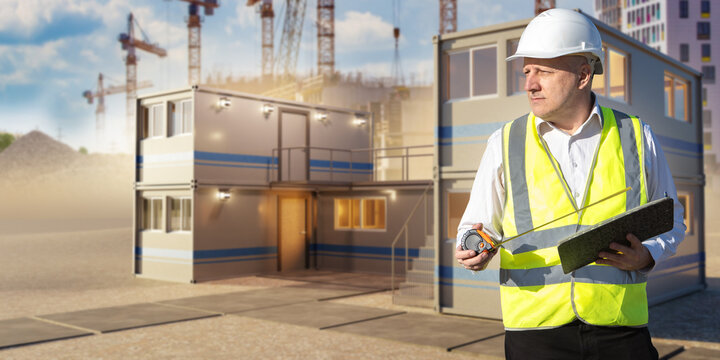 Construction site office. Civil engineer stands beside a modular building and checks measurements for a temporary office at a development project.