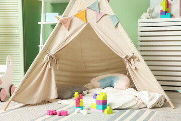 Cute wigwam and building blocks in stylish child's room © New Africa