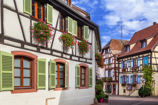 Picturesque historic street in Eguisheim Alsace France. Traditional half timbered architecture and facade under cloudy sky