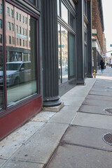 Obraz premium Person walking past storefront windows in city