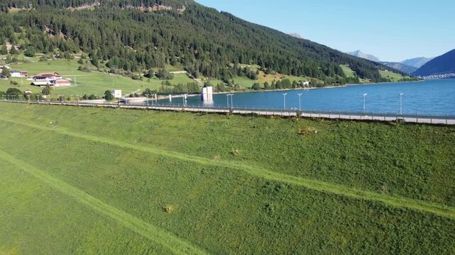 Aerial drone view of Resia Lake dam: sustainable hydroelectric power infrastructure, Renewable energy production, and environmental engineering in the Italian Alps landscape