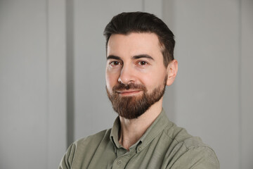 Fototapeta premium Portrait of handsome man near white wall indoors