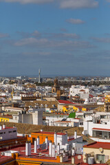 Obraz premium Seville, Andalusia, Spain panoramic cityscape view from above, showcasing dense rooftops, historic buildings, the iconic Torre Sevilla, and distant arched structures under a clear blue sky