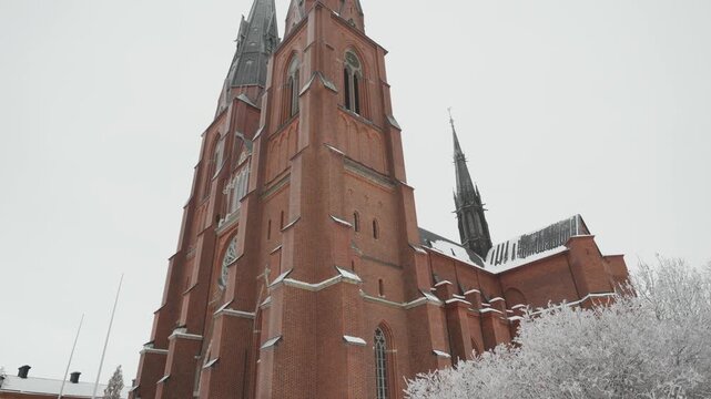 A breathtaking view of a majestic cathedral towering amidst a serene snowy landscape, showcasing intricate architecture against the white backdrop of winter.