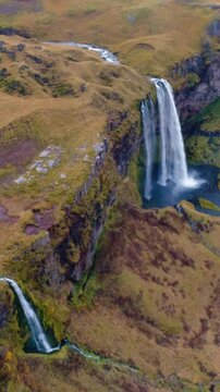 Epic Waterfall in scenic iceland nature, aerial shot - vertical video